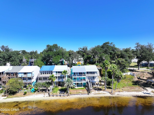 back of property featuring a water view and stairs