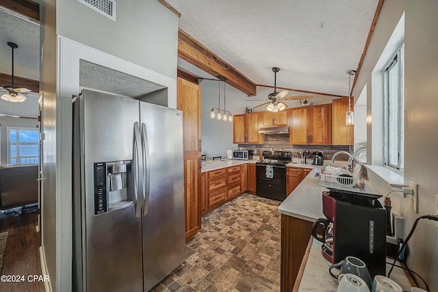 kitchen featuring under cabinet range hood, a sink, light countertops, appliances with stainless steel finishes, and decorative light fixtures