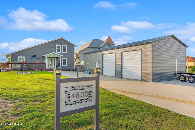 view of front facade featuring a front yard, an outdoor structure, and a garage