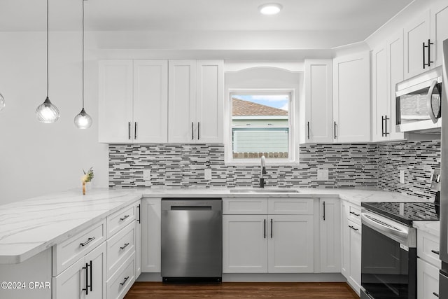 kitchen featuring hanging light fixtures, white cabinets, kitchen peninsula, and stainless steel appliances