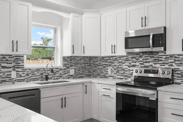 kitchen featuring appliances with stainless steel finishes, sink, decorative backsplash, and white cabinets