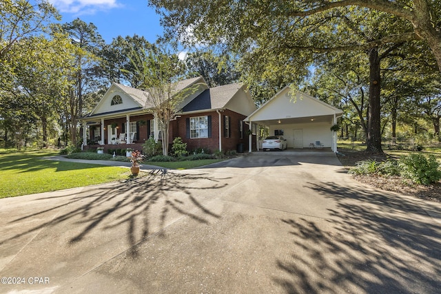 view of front of house featuring a carport, covered porch, and a front yard