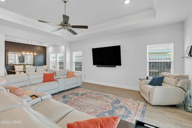 living room featuring ceiling fan with notable chandelier, a wealth of natural light, and wood-type flooring