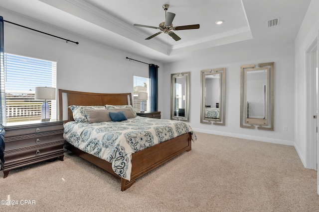 carpeted bedroom featuring ceiling fan and a raised ceiling