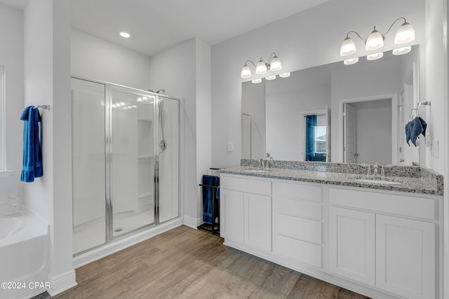 bathroom with hardwood / wood-style flooring, vanity, and separate shower and tub