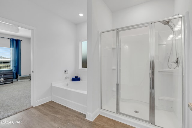 bathroom featuring shower with separate bathtub and hardwood / wood-style floors