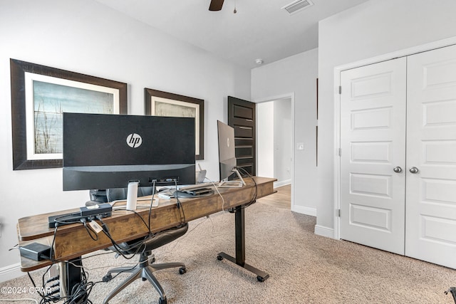 carpeted home office featuring ceiling fan