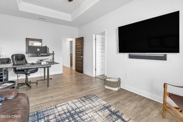 office featuring crown molding, hardwood / wood-style flooring, and a raised ceiling