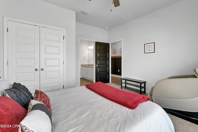 bedroom featuring a closet, light colored carpet, ceiling fan, and ensuite bath