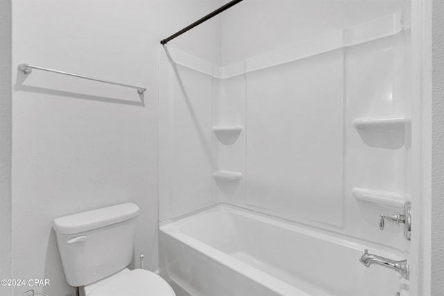 bathroom featuring washtub / shower combination and toilet