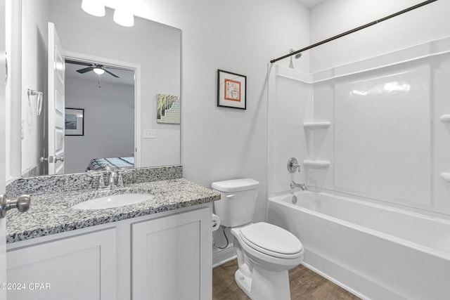 full bathroom with bathing tub / shower combination, vanity, hardwood / wood-style flooring, toilet, and ceiling fan