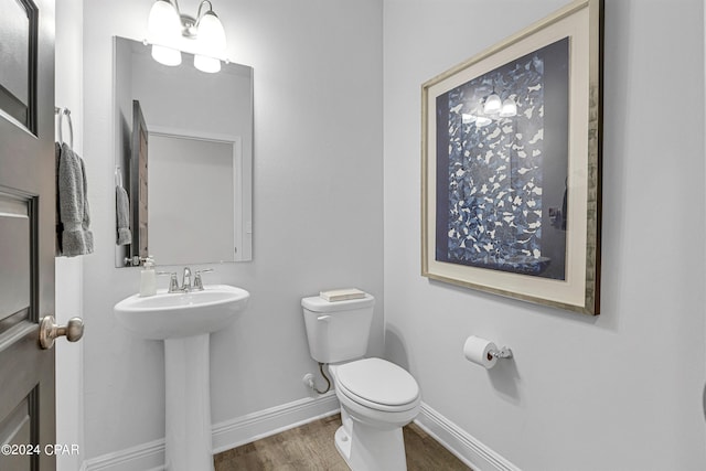 bathroom featuring hardwood / wood-style flooring, toilet, and sink