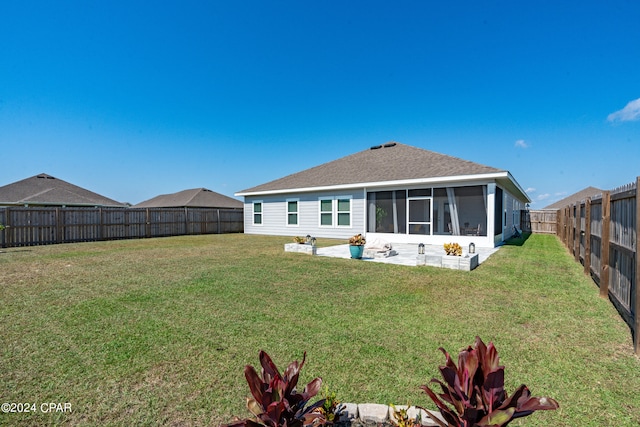 back of property with a sunroom and a yard