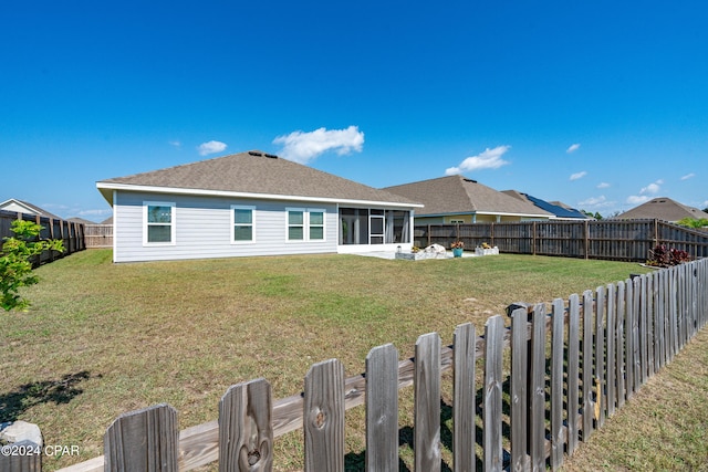 back of property with a sunroom and a yard