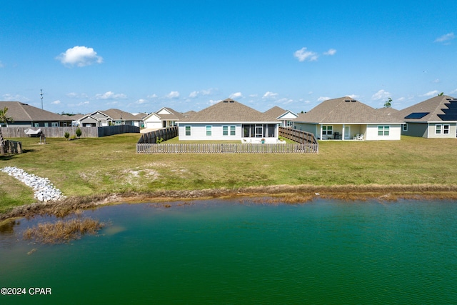 rear view of property with a water view and a yard