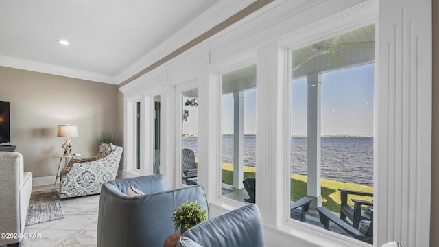 interior space with ceiling fan, a water view, and a wealth of natural light