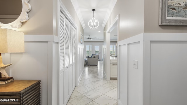 hall with a notable chandelier and crown molding