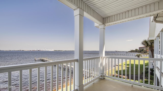 balcony with a water view and a dock