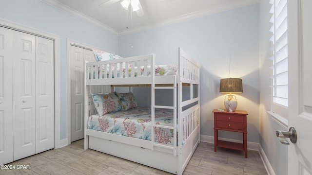 bedroom with multiple closets, ceiling fan, and crown molding