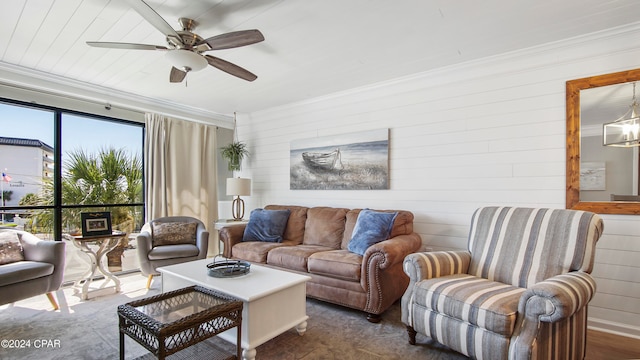 living room featuring ornamental molding, ceiling fan, and wood walls