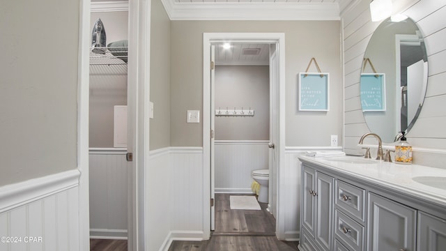 bathroom with vanity, ornamental molding, hardwood / wood-style flooring, and toilet