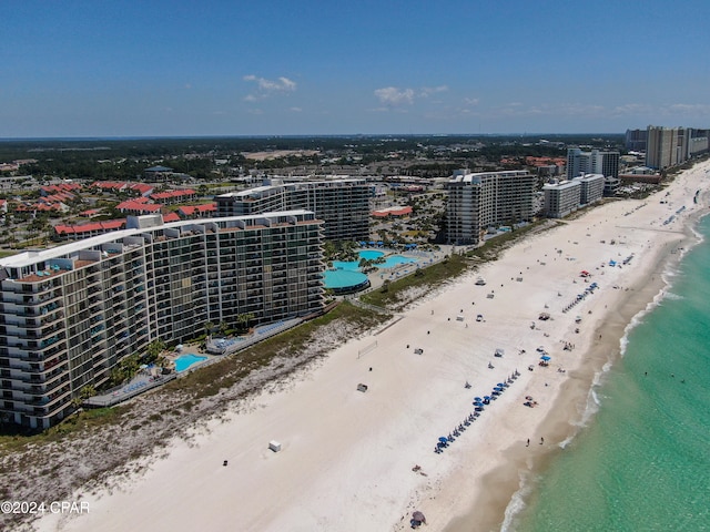 birds eye view of property featuring a water view and a beach view