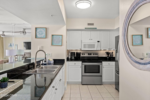 kitchen featuring white cabinetry, sink, ceiling fan, light tile patterned floors, and appliances with stainless steel finishes