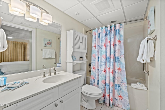 full bathroom featuring a paneled ceiling, vanity, tile patterned floors, toilet, and shower / tub combo with curtain