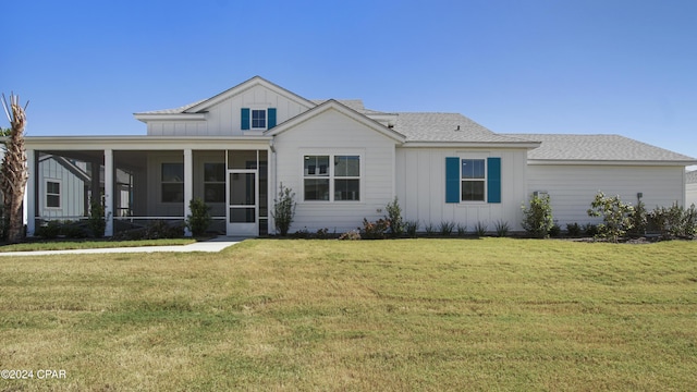 view of front facade featuring a front yard and a sunroom