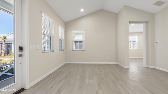 unfurnished room with light hardwood / wood-style floors and vaulted ceiling