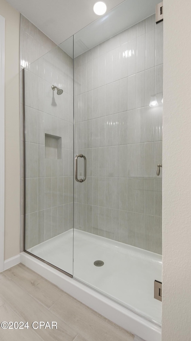 bathroom featuring hardwood / wood-style floors and a shower with door