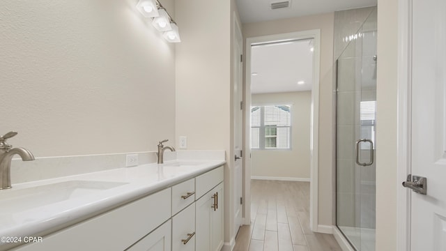 bathroom with hardwood / wood-style flooring, vanity, and walk in shower