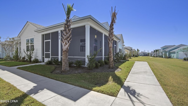 view of property exterior with a sunroom and a lawn