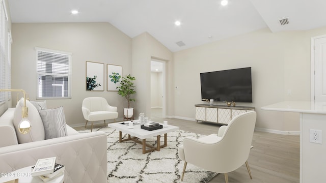 living room with light hardwood / wood-style floors and lofted ceiling