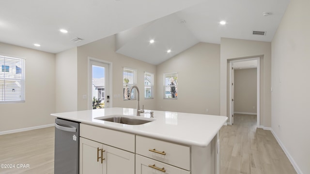 kitchen with lofted ceiling, sink, light hardwood / wood-style flooring, stainless steel dishwasher, and an island with sink