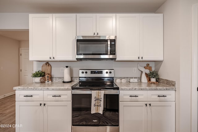 kitchen featuring white cabinetry, appliances with stainless steel finishes, and wood-type flooring