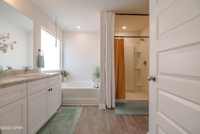 bathroom with vanity, hardwood / wood-style flooring, and independent shower and bath