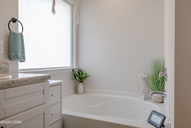 bathroom with vanity and a tub