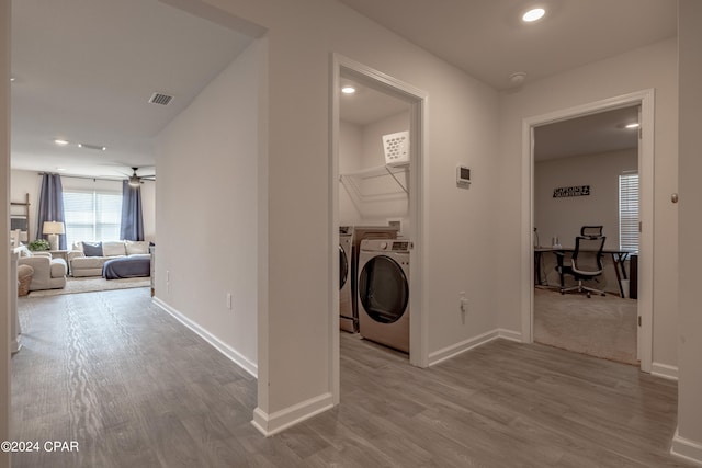 laundry area with light hardwood / wood-style floors, washing machine and dryer, and ceiling fan