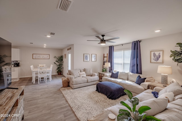 living room with light hardwood / wood-style flooring and ceiling fan