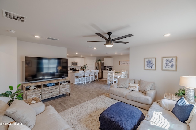 living room featuring light hardwood / wood-style floors and ceiling fan