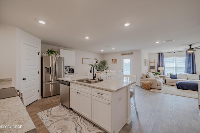 kitchen featuring white cabinetry, a kitchen island with sink, light hardwood / wood-style flooring, stainless steel appliances, and sink