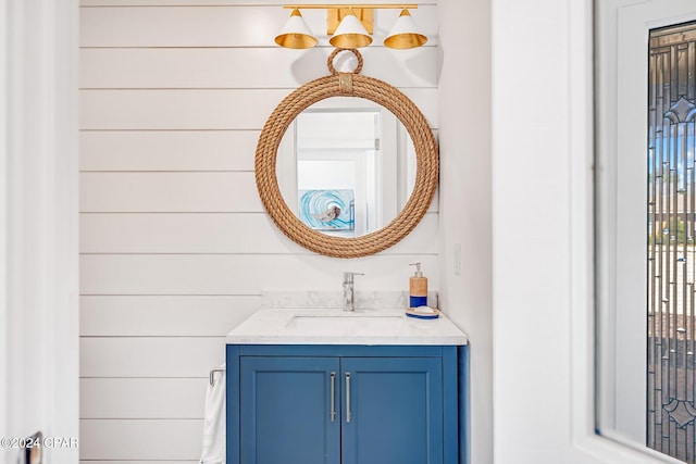 bathroom featuring vanity and wooden walls