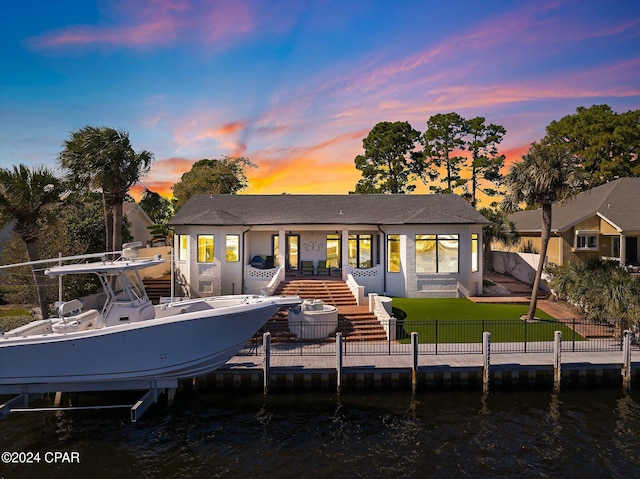 443 Wahoo Rd, Panama City Beach, FL 32408 - back of house at dusk with boat lift, a water view, stairway, and roof with shingles