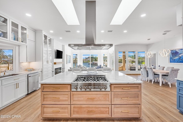 kitchen featuring light stone countertops, white cabinetry, light hardwood / wood-style flooring, and stainless steel appliances