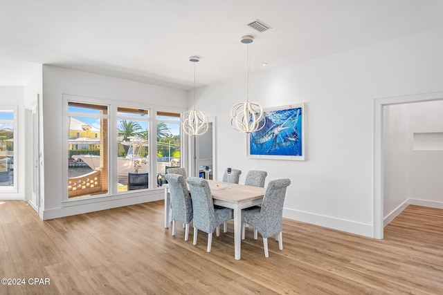 dining area featuring light hardwood / wood-style floors and an inviting chandelier