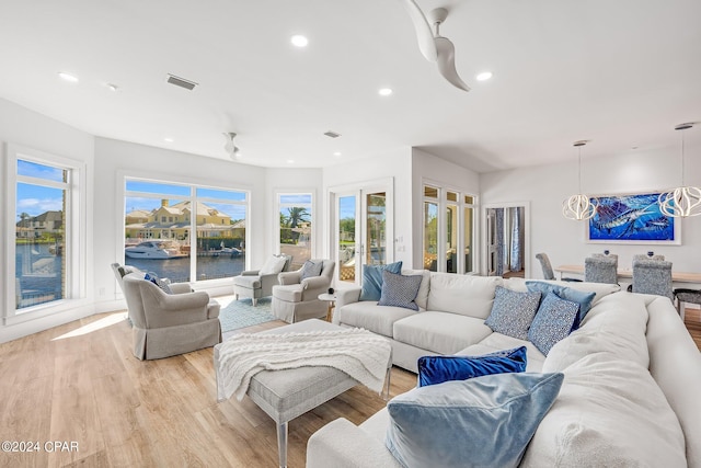 living room with a water view and light wood-type flooring