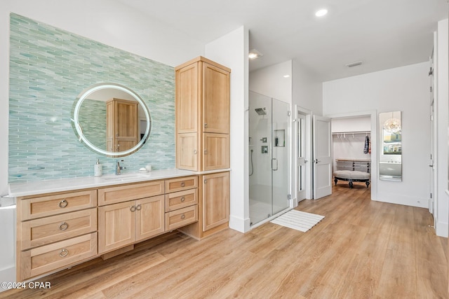 443 Wahoo Rd, Panama City Beach, FL 32408 - full bathroom featuring wood finished floors, a stall shower, vanity, backsplash, and a spacious closet