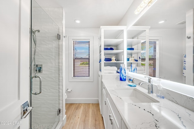 bathroom featuring vanity, a shower with shower door, wood-type flooring, and toilet