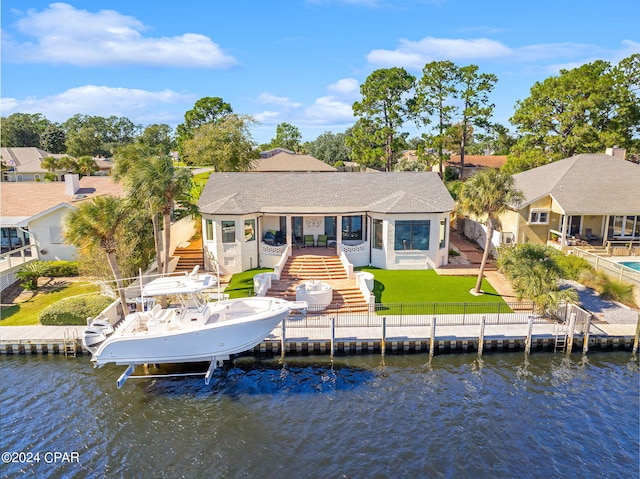 back of house featuring a water view, a patio area, and a lawn